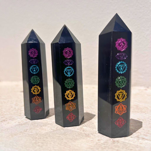 A Obsidiana, associada ao enraizamento e à proteção e os símbolos dos chakras, que representam equilíbrio, consciência e harmonia energética.